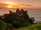 Zamek Dunluce Castle, Irlandia Północna, Hrabstwo Antrim, Wybrzeże, Ruiny, Zachód słońca, Morze