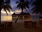 Malediwy, Wyspa Lankanfushi, Hotel Gili Lankanfushi Maldives, Domki, Morze, Palmy, Wieczór, Plaża, Stoły, Wakacje